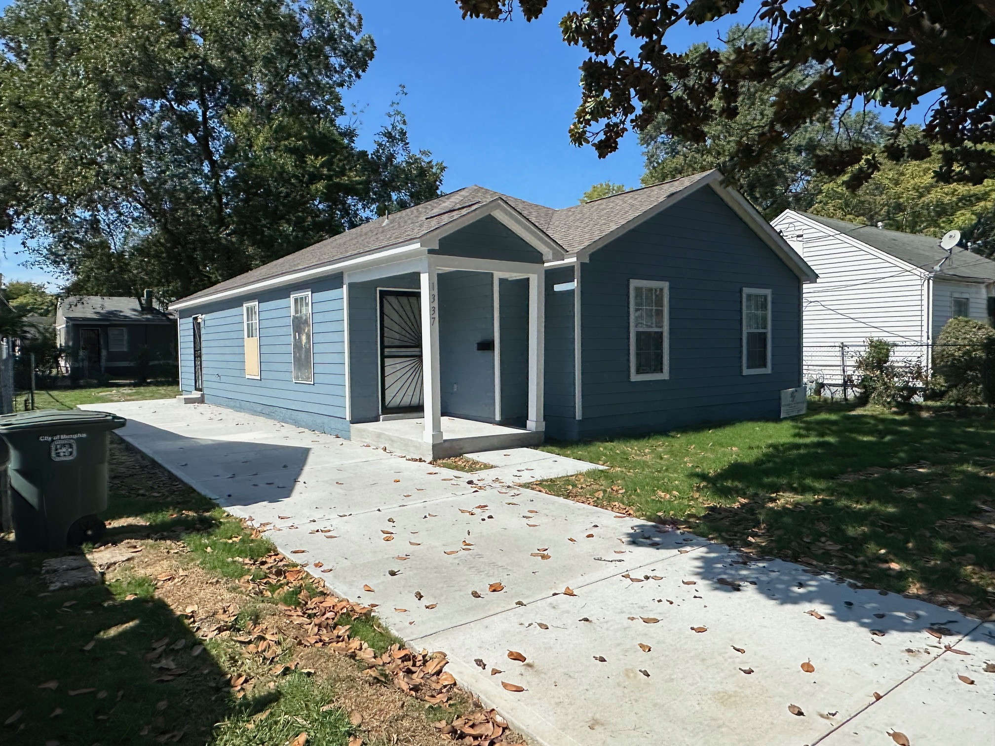 Angled view of new construction home for sale in Memphis TN with fresh siding and sidewalk