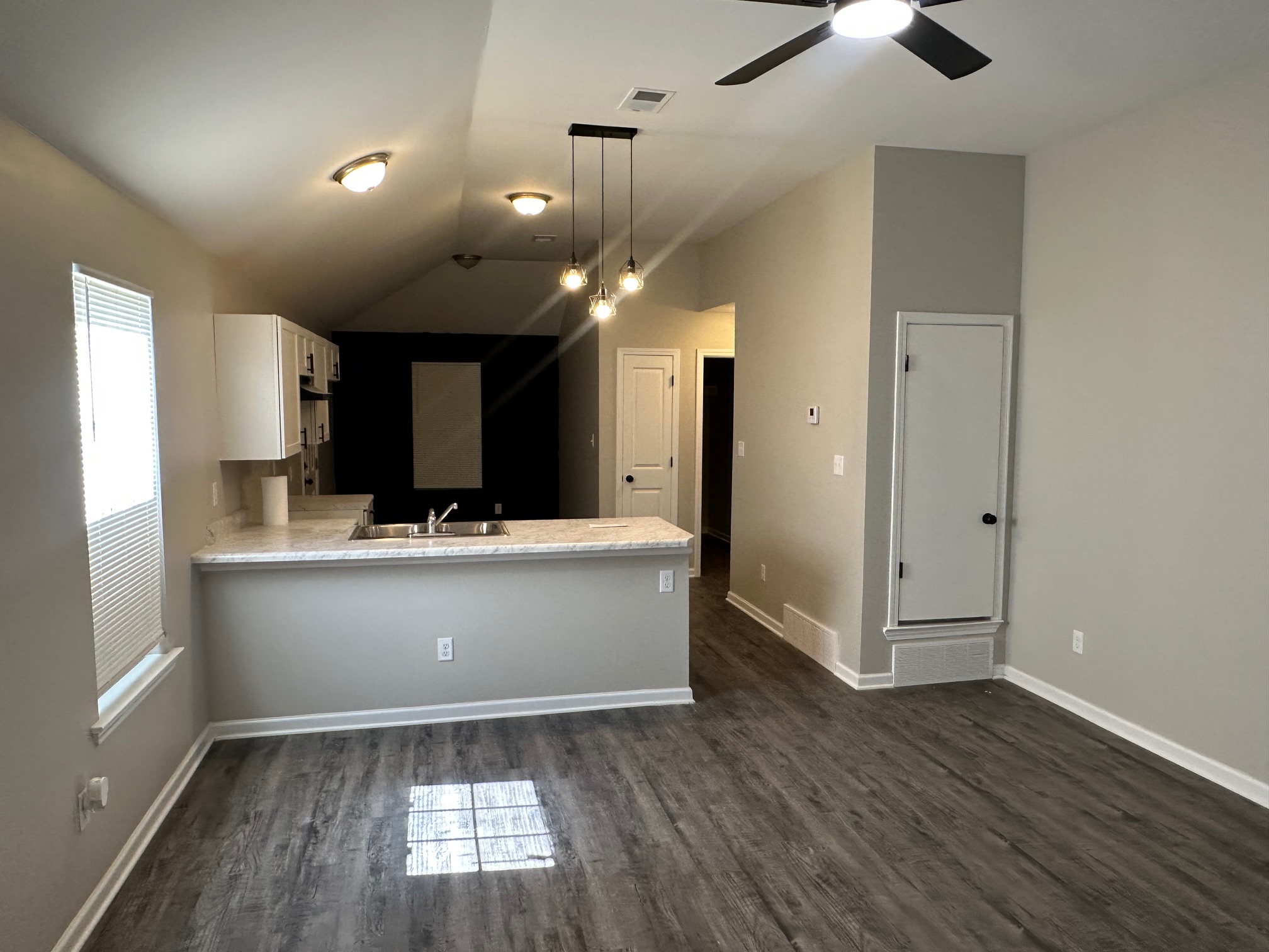 Open-concept kitchen and living area with vaulted ceilings and modern lighting in Memphis home