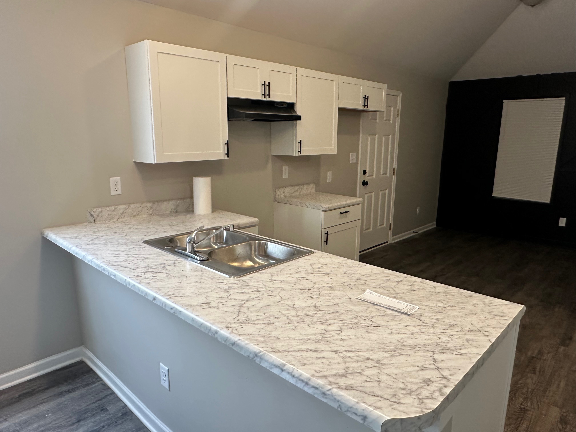 Kitchen island with marble-style counters and white shaker cabinets in investment home 38108