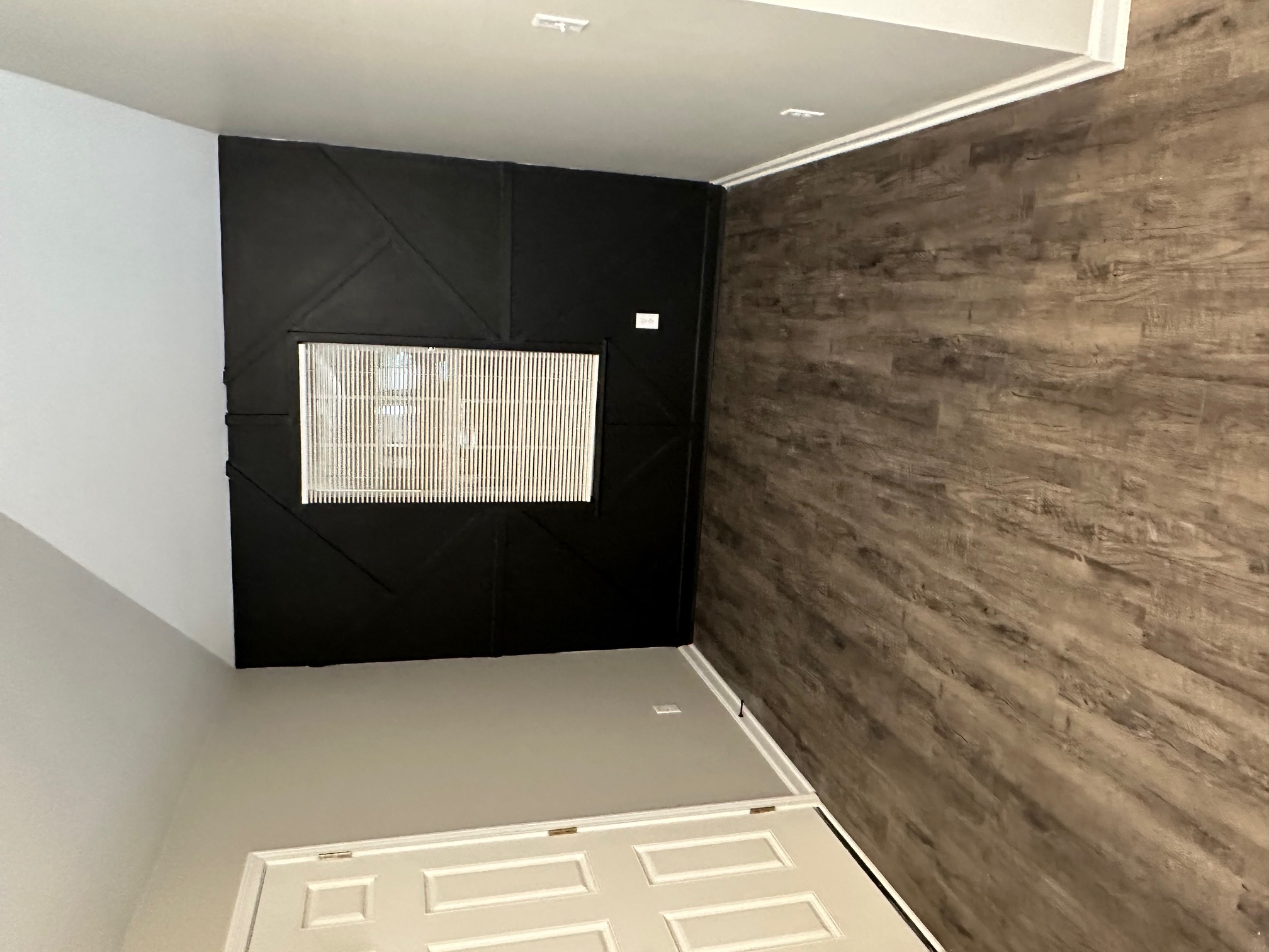 Living room with black geometric accent wall and ceiling fan in Memphis rental property
