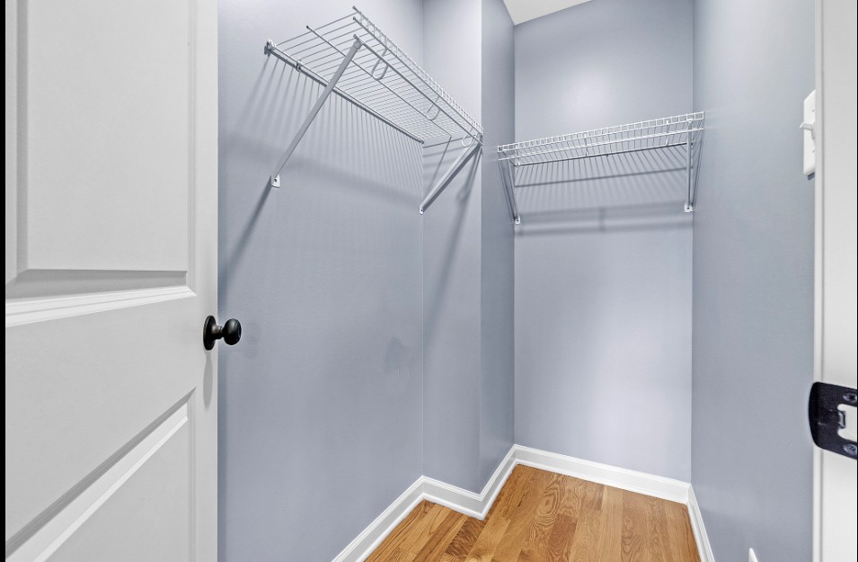 Walk-in closet with hardwood flooring and built-in shelving in Memphis rental home 38107 for sale