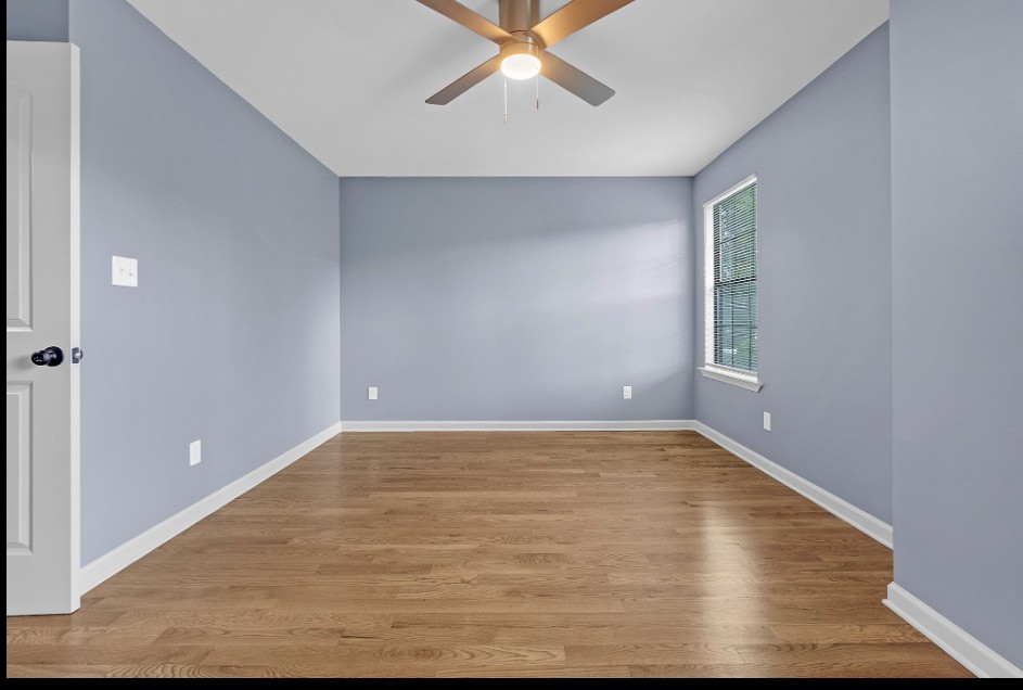 Bedroom with wood floors and ceiling fan in renovated Memphis property for sale 38107