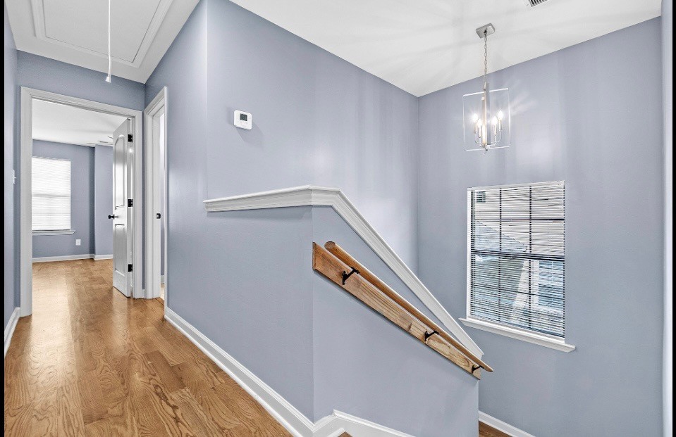 Upper stair landing with chandelier and natural light in Memphis rental home 38107