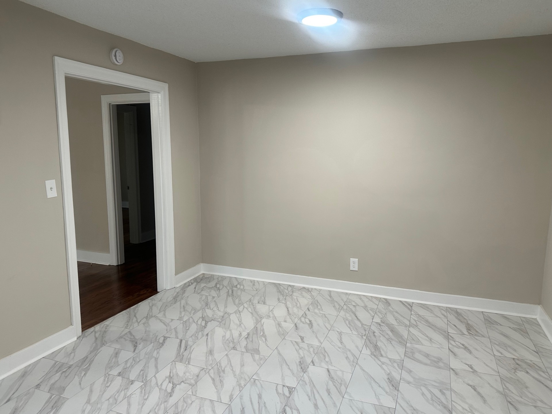 Spacious bedroom or living area with large windows and refinished hardwood floors