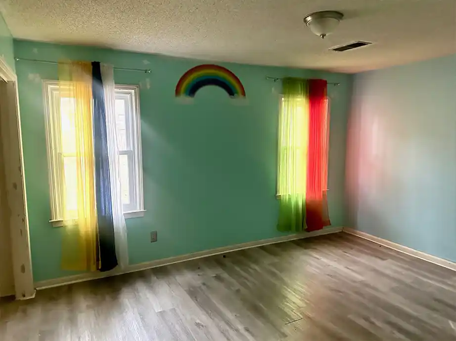 Bedroom with LVP flooring and large window providing daylight