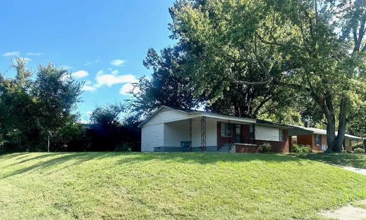 Vertical image showing spacious bedroom with updated flooring and paint