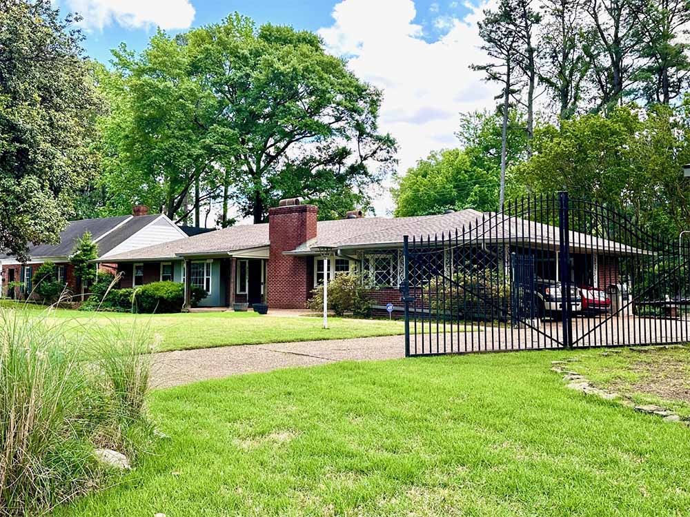 Front view of East Memphis home for sale with gated drive and 2-car garage