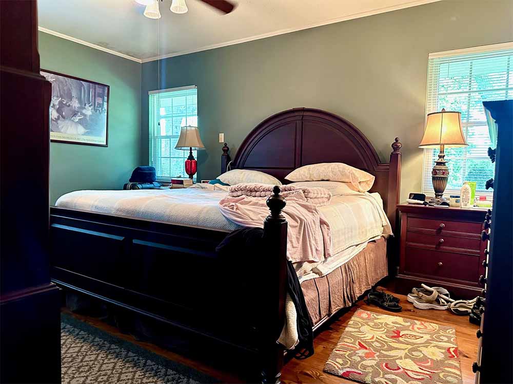 Second bedroom with ceiling fan and natural pine floors