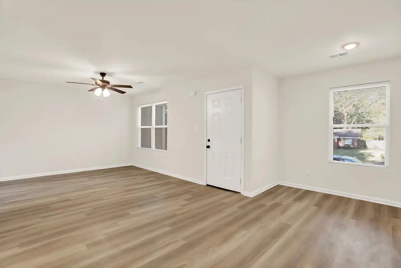 Living room entry at 5140 Blacksmith Drive featuring front door, window and bright interior