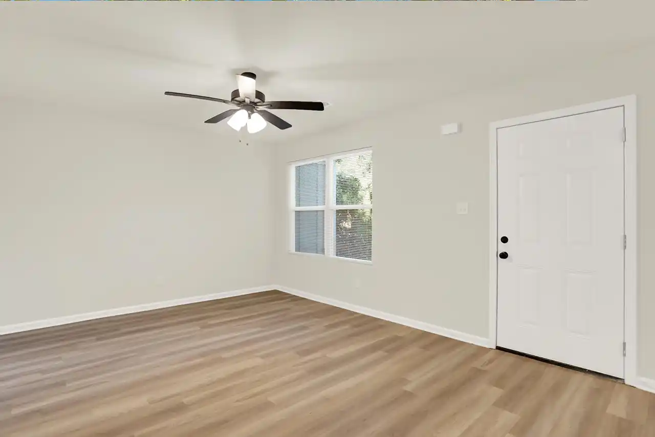 Front-facing living room with wide window and entry door at Blacksmith Drive property
