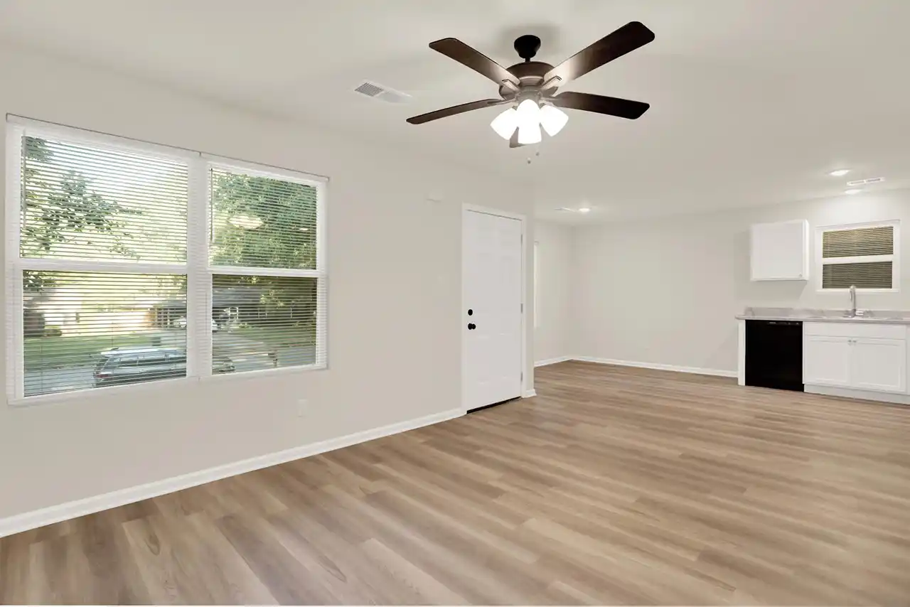 Open-concept layout connecting kitchen and living space with sleek flooring