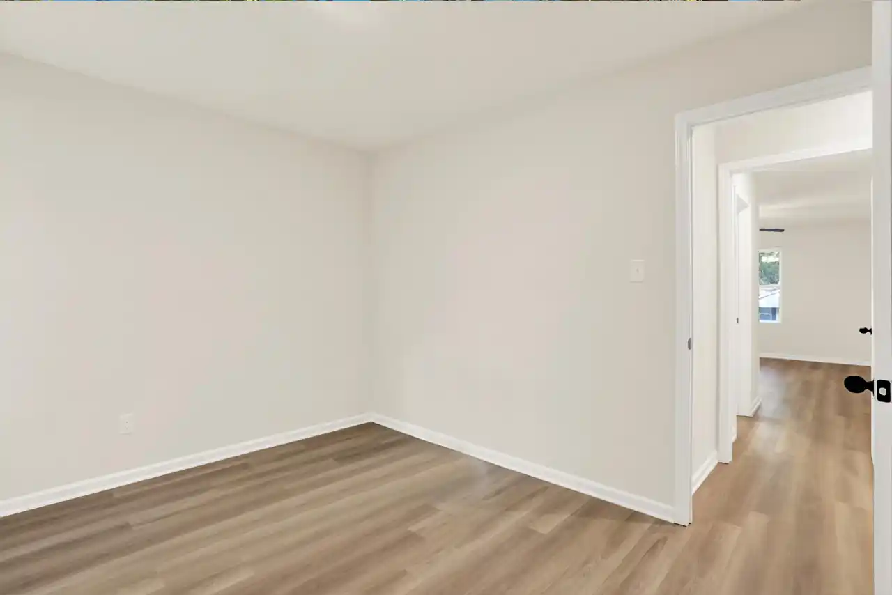 Bedroom with view of hallway, neutral walls and closet space in Memphis home