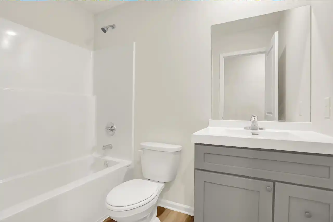 Full hallway bath with combination tub/shower and sleek white vanity