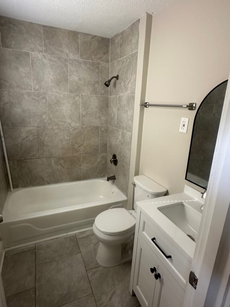 Newly remodeled bathroom with tiled walls and updated fixtures