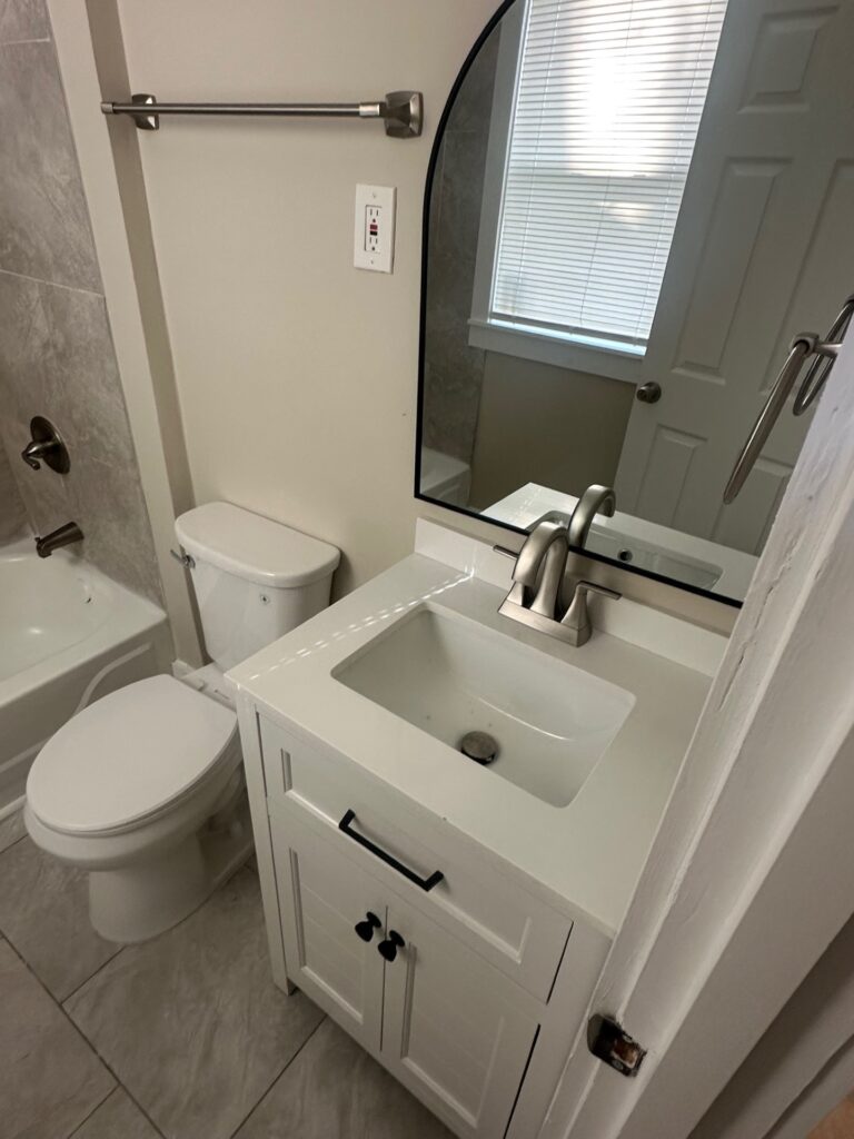 Newly remodeled bathroom with tiled walls and updated fixtures