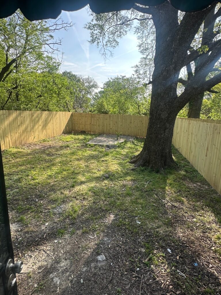 Backyard with brand-new wood privacy fence and grassy area