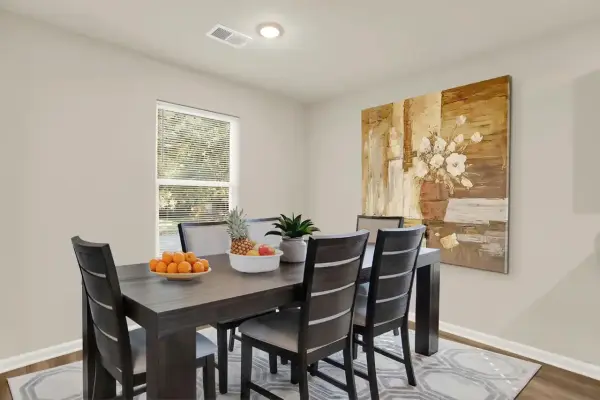 Dining nook set for four, positioned near kitchen in open floor plan