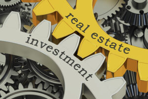 Graphic showing gears with interlocking teeth and the words real estate investment printed on them.